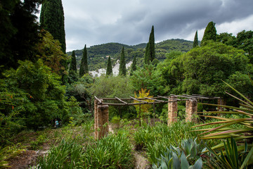 Fototapeta na wymiar Old building in big garden into green hills with cypresses