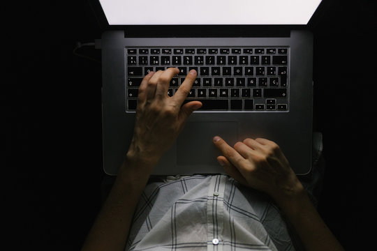 young woman with laptop on the sofa at night