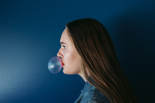 Quirky teenage girl blowing bubble gum