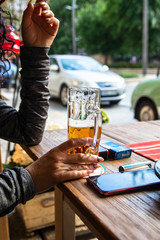 Woman drinking beer in cafe garden by the street in Budapest