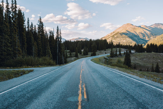 Colorado mountain road, with sunset touching mountains behind.