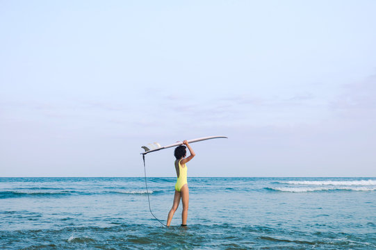 Unrecognizable surfer walking into sea