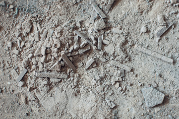 Gray background of waste construction waste with pieces of dusty drywall