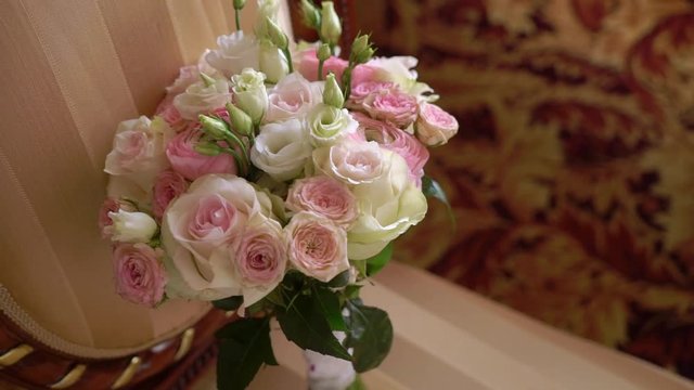 Bridal bouquet of white and pink roses on chair