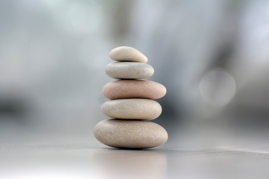 Harmony and balance, cairns, simple poise pebbles on wooden light white gray background, simplicity rock zen sculpture