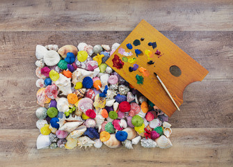 Painted sea shells. Collection of shells painted in different colors. Color pallet with paint brush