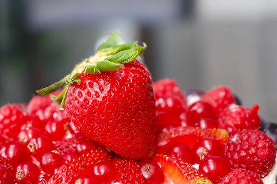 Strawberry on top of variety of red berries