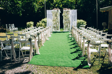 Fototapeta na wymiar wedding ceremony in nature. Rows of white chairs on the lawn.