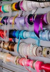 multicolored threads and ribbons. Background for the store selling reels with ribbons. materials for sewing and creativity. Fashionable craft of women.