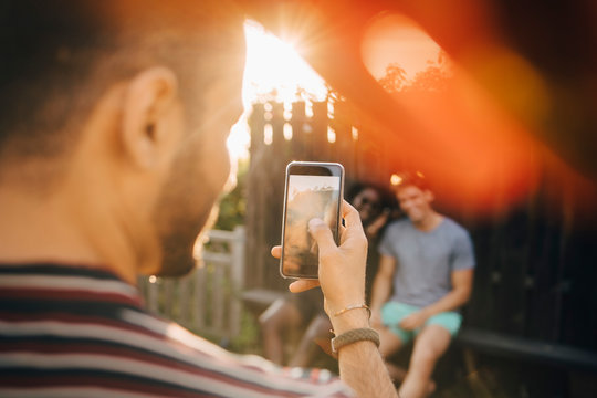 Man tar bild med smartphone p&Acirc; v&permil;nner i tr&permil;dg&Acirc;rd