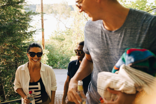 Leende kvinna g&Acirc;r med v&permil;nner och pratar i trappa i park