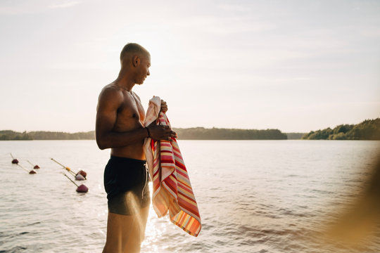 Leende man st&Acirc;r med handduk p&Acirc; brygga