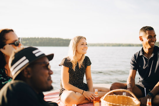 Glada v&permil;nner sitter p&Acirc; brygga och pratar under sommardag