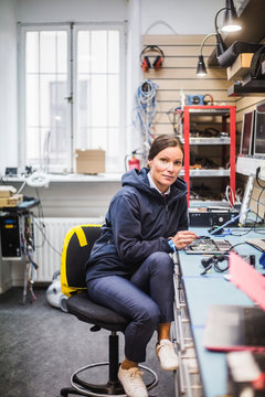 Portr&permil;tt av kvinnlig tekniker vid arbetsb&permil;nk i verkstad
