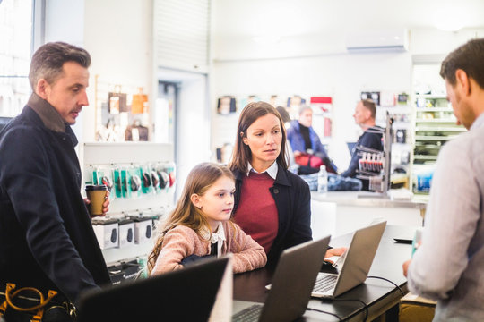 Familj tittar p&Acirc; b&permil;rbara datorer i elektronikaff&permil;r