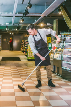 Flitig &permil;gare sopar golvet i matvarubutik