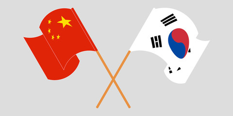 Crossed and waving flags of South Korea and China.