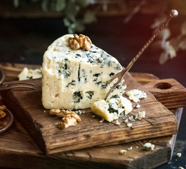 blue cheese on a wooden board. Close up. Toning