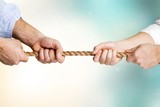 Business people pulling rope in opposite directions at office