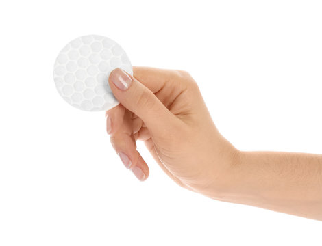Woman holding cotton pad on white background, closeup