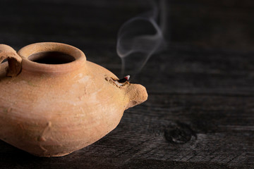 A Handmade Oil Lamp with a Smoldering Wick