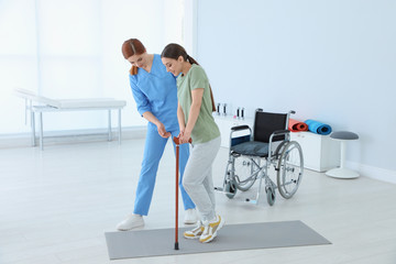 Professional physiotherapist working with female patient in rehabilitation center