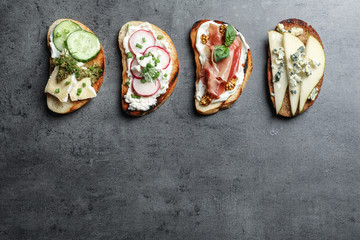 Different tasty bruschettas and space for text on grey background, flat lay