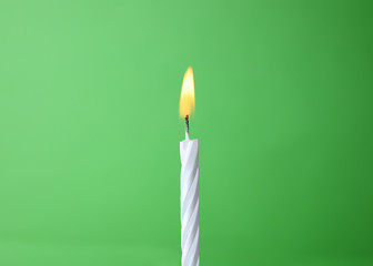 Burning birthday cake candle on color background. Space for text