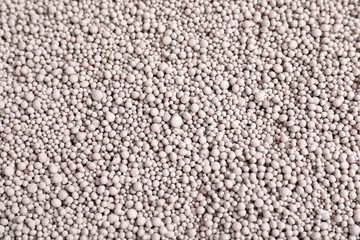 Textured chemical fertilizer for gardening as background, top view