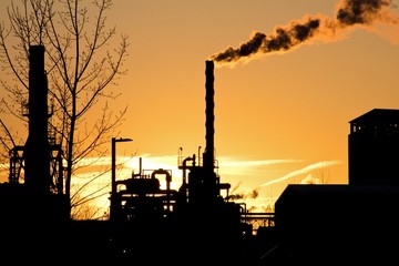 Usine pétrolière sur fond de coucher de soleil orange