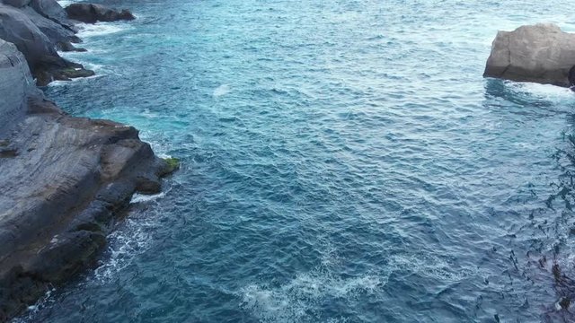 Aerial Drone Azores Portugal camera flies through waves on the rocks