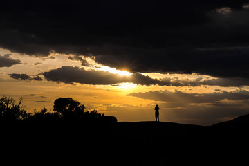 Silhouette of person looking at sunset