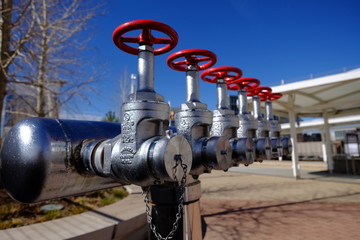 low angle view of metal valves with red handles