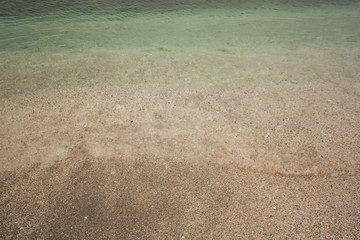 Green azure water texture on the yellow sand background in Yeşilköy, Istanbul, Turkey