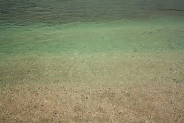 Green azure water texture on the yellow sand background in Yeşilköy, Istanbul, Turkey