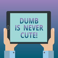 Handwriting text writing Dumb Is Never Cute. Concept meaning To be stupid ignorant is never an attractive feature Hu analysis Hand Holding Blank Screen Tablet Smartphone Display Unit photo