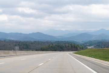 Smoky Mountains near Asheville, North Carolina near Tennessee border with cloudy sky and forest trees on South 25 highway road with cars