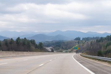 Smoky Mountains near Asheville with cloudy sky and forest trees on South 25 highway road and sign Burnsville and Spruce Pine