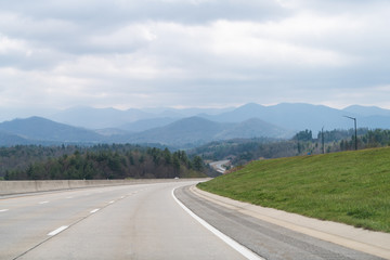 Smoky Mountains near Asheville and Tennessee border with cloudy sky and forest trees on South 25 highway road