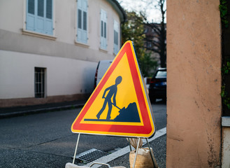 Construction roadworks warning sign ahead on French tiny street
