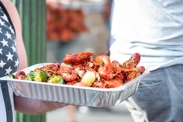New Orleans, USA Louisiana town with people by restaurant eating seafood lobsters holding trays