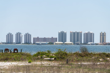 Fototapeta premium Cityscape, skyline of Navarre beach city town on Pensacola bay pcean sea coast shore with many high-rise apartment condo condominium buildings towers in Florida Panhandle