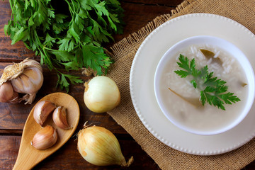 congee in ceramic bowl on rustic wooden table, traditional rice porridge typical of Asian cuisine