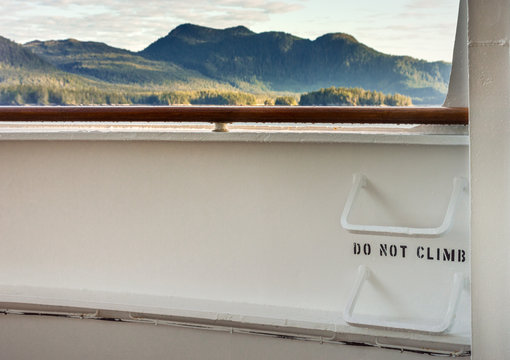 Metal ladder rungs on cruise ship deck with view of mountain scenery in background ner Ketchikan, Alaska.