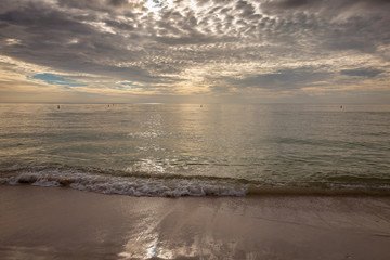 Sand, surf, ocean, clouds, and sky in a wide angle at the beach