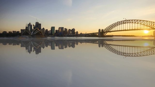 4k time lapse from sunset to sunrise, day to night to day at Sydney city skyline with reflection effect. Tilt up