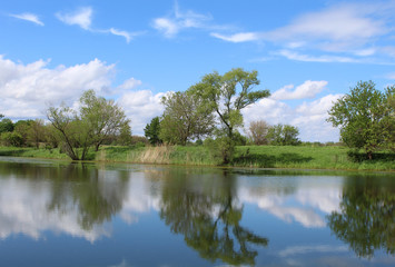 Fototapeta na wymiar Turtle Pond at Midewin National Tallgrass Prairie with intereting clouds and a beautiful reflection