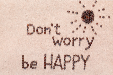 The words Don't worry be happy under a sun all made with coffee beans.