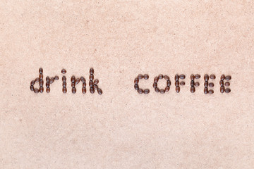 The words drink coffee written with coffee beans , shot from above.