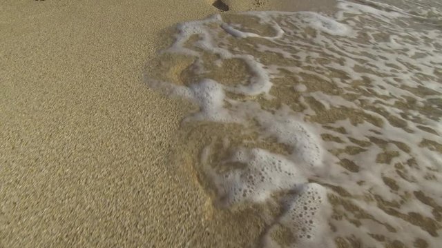 Little footprints in sand with waves.
